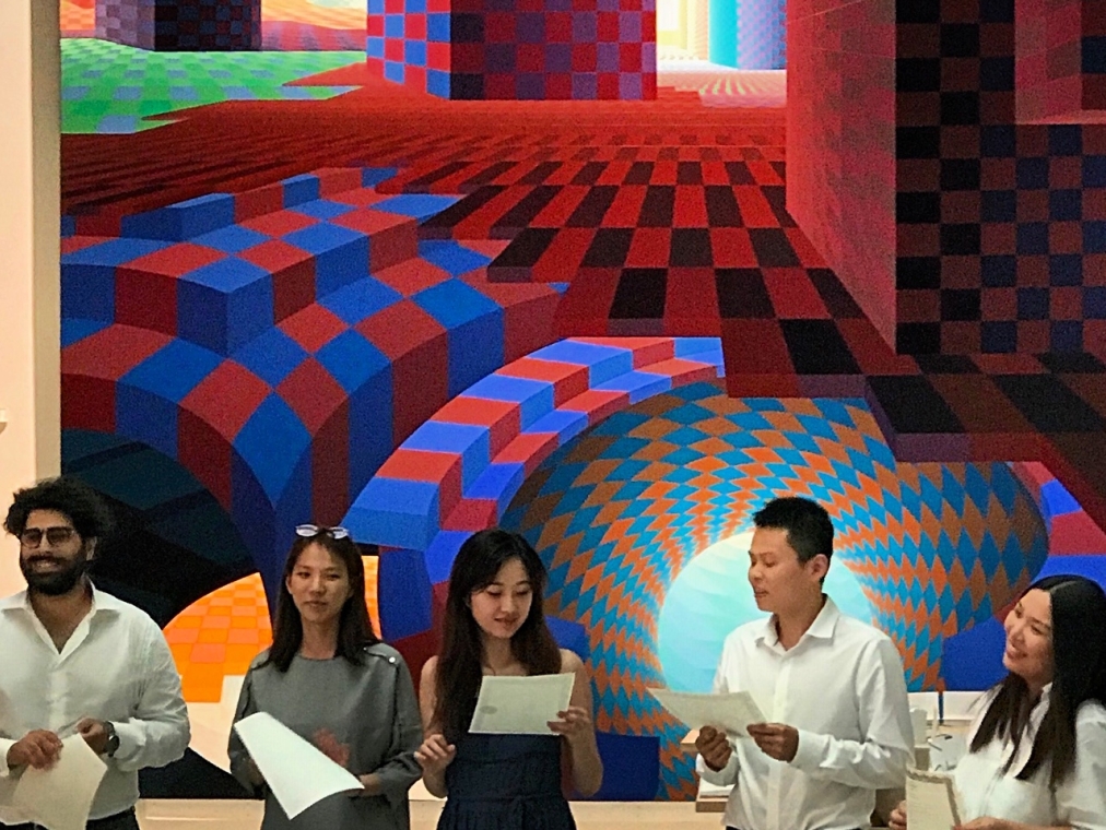 Five students stand in front of a large colorful abstract Al Held painting.