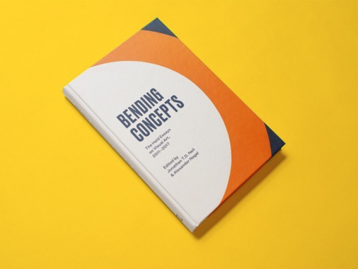 Bending Concepts book with a white, orange, and navy cover, resting on a bright yellow backdrop.